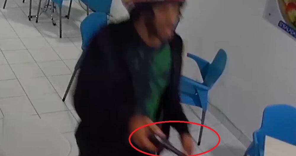 Momento exacto en el que el ladrón saca su pistola para intimidar a la religiosa.