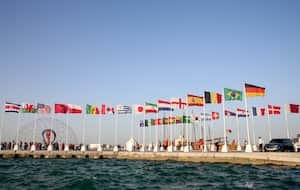 Una vista general muestra las banderas de los países clasificados para la Copa del Mundo de 2022 en la capital de Qatar, Doha, durante una ceremonia de izamiento de la bandera de los últimos países restantes en clasificar, el 16 de junio de 2022. (Foto de Mustafa ABUMUNES / AFP)