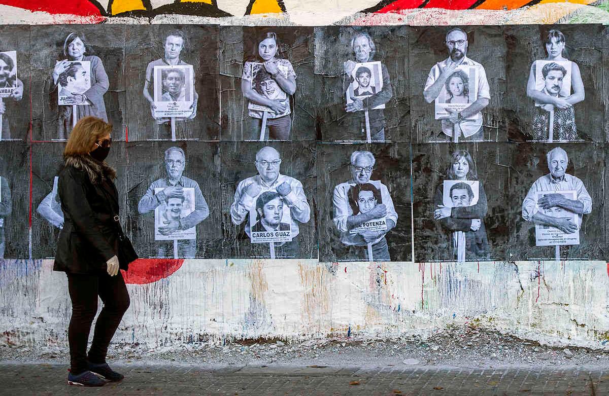 Una mujer camina frente a un mural que muestra imágenes de líderes uruguayos posando con retratos de personas desaparecidas durante la dictadura militar (1973-1985) en Montevideo, Uruguay. El 20 de mayo es el 25 aniversario de la Marcha del Silencio, que cada año recuerda el asesinato de dos congresistas uruguayos. La marcha no tendrá lugar este año para evitar la propagación de nuevos coronavirus. (Foto AP-Matilde Campodonico)
