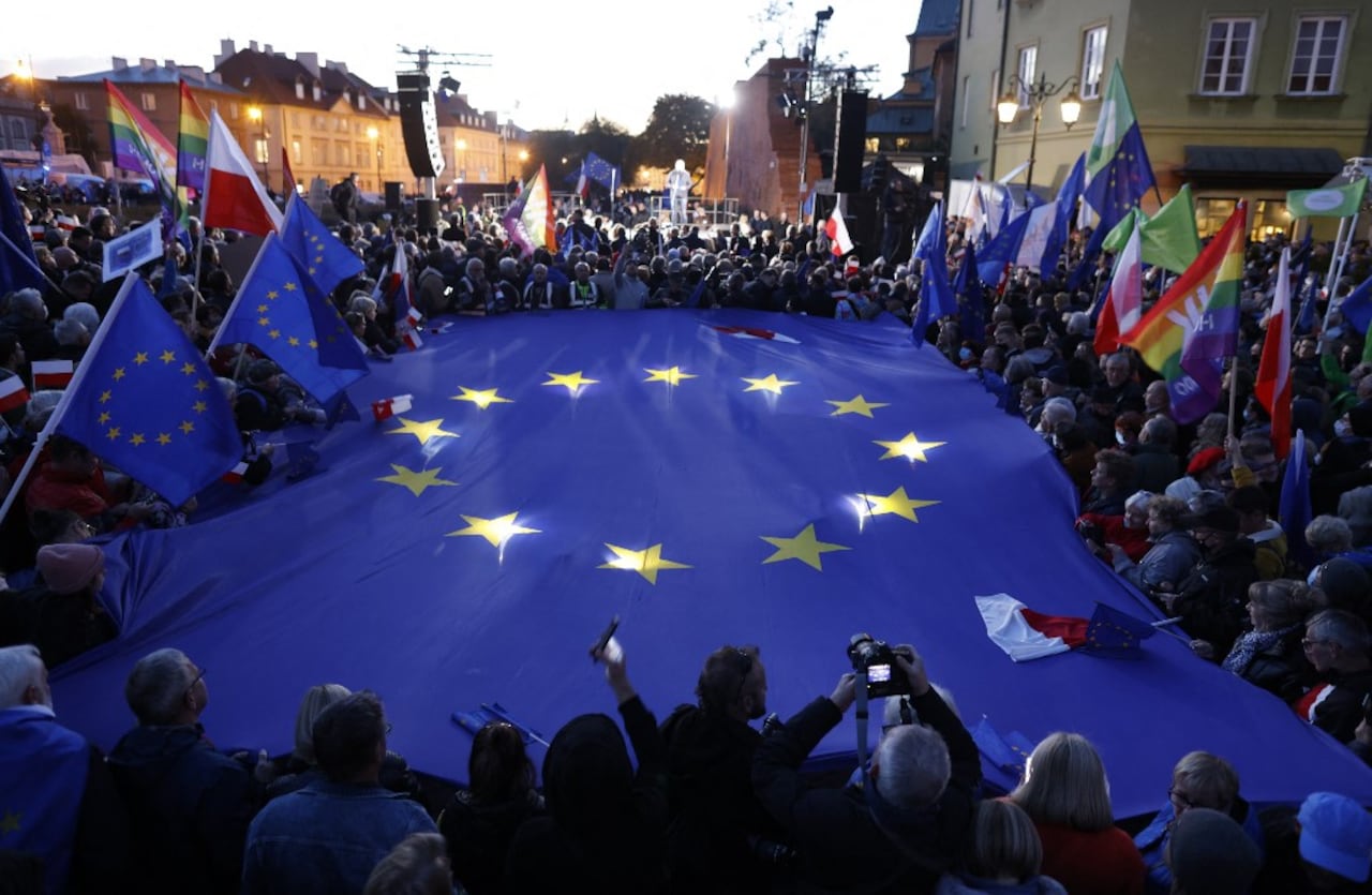Los participantes sostienen una gran bandera de la UE mientras participan en una manifestación a favor de la UE tras un fallo del Tribunal Constitucional contra la primacía de la legislación de la UE en Polonia, en Varsovia el 10 de octubre de 2021.  (Photo by Wojtek RADWANSKI / AFP)