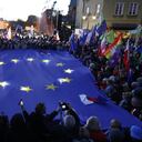 Los participantes sostienen una gran bandera de la UE mientras participan en una manifestación a favor de la UE tras un fallo del Tribunal Constitucional contra la primacía de la legislación de la UE en Polonia, en Varsovia el 10 de octubre de 2021. (Photo by Wojtek RADWANSKI / AFP)