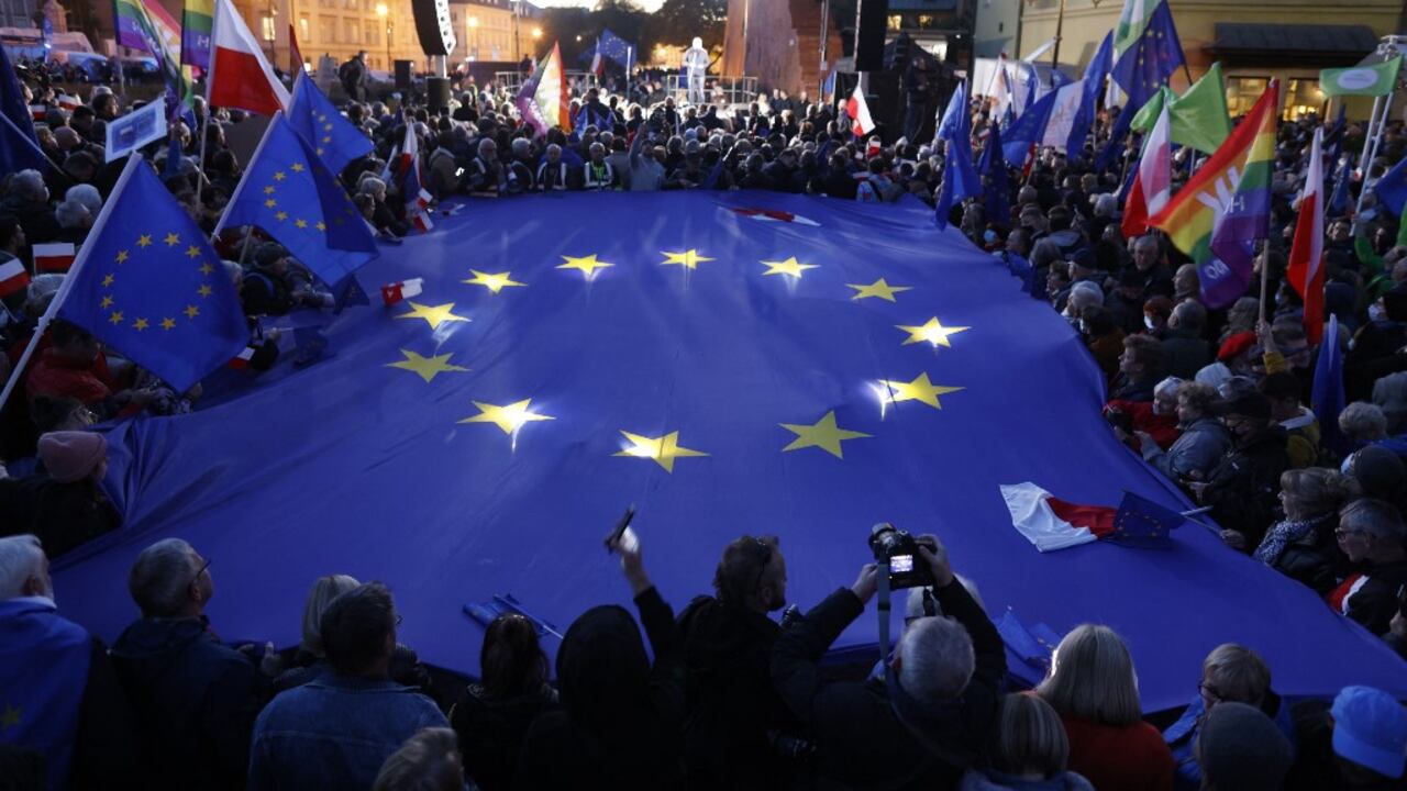 Los participantes sostienen una gran bandera de la UE mientras participan en una manifestación a favor de la UE tras un fallo del Tribunal Constitucional contra la primacía de la legislación de la UE en Polonia, en Varsovia el 10 de octubre de 2021. (Photo by Wojtek RADWANSKI / AFP)