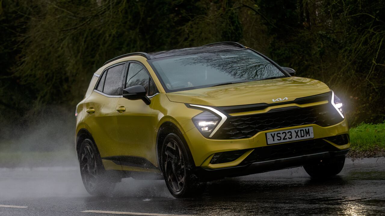 Milton Keynes,Bucks,UK - Dec 9th 2023: 2023 yellow Kia Sportage GT line SUV car driving on a wet road, in the rain with headlights on