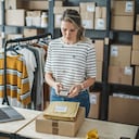 Mujer madura en tienda online. Es propietaria de una pequeña tienda online. Recepción de pedidos y cajas de embalaje para entrega.