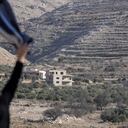 Salma Safadi agita una camisa hacia su hermana Sawsan Safadi, quien se encuentra dentro de la zona de amortiguación cerca de la llamada Línea Alfa que separa los Altos del Golán controlados por Israel de Siria, en la ciudad de Majdal Shams, el martes 17 de diciembre de 2024.