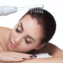 El médico-cosmetólogo realiza el procedimiento Terapia de microcorriente En el cabello de una bella y joven mujer en un salón de belleza.Cosmetología y cuidado profesional de la piel.