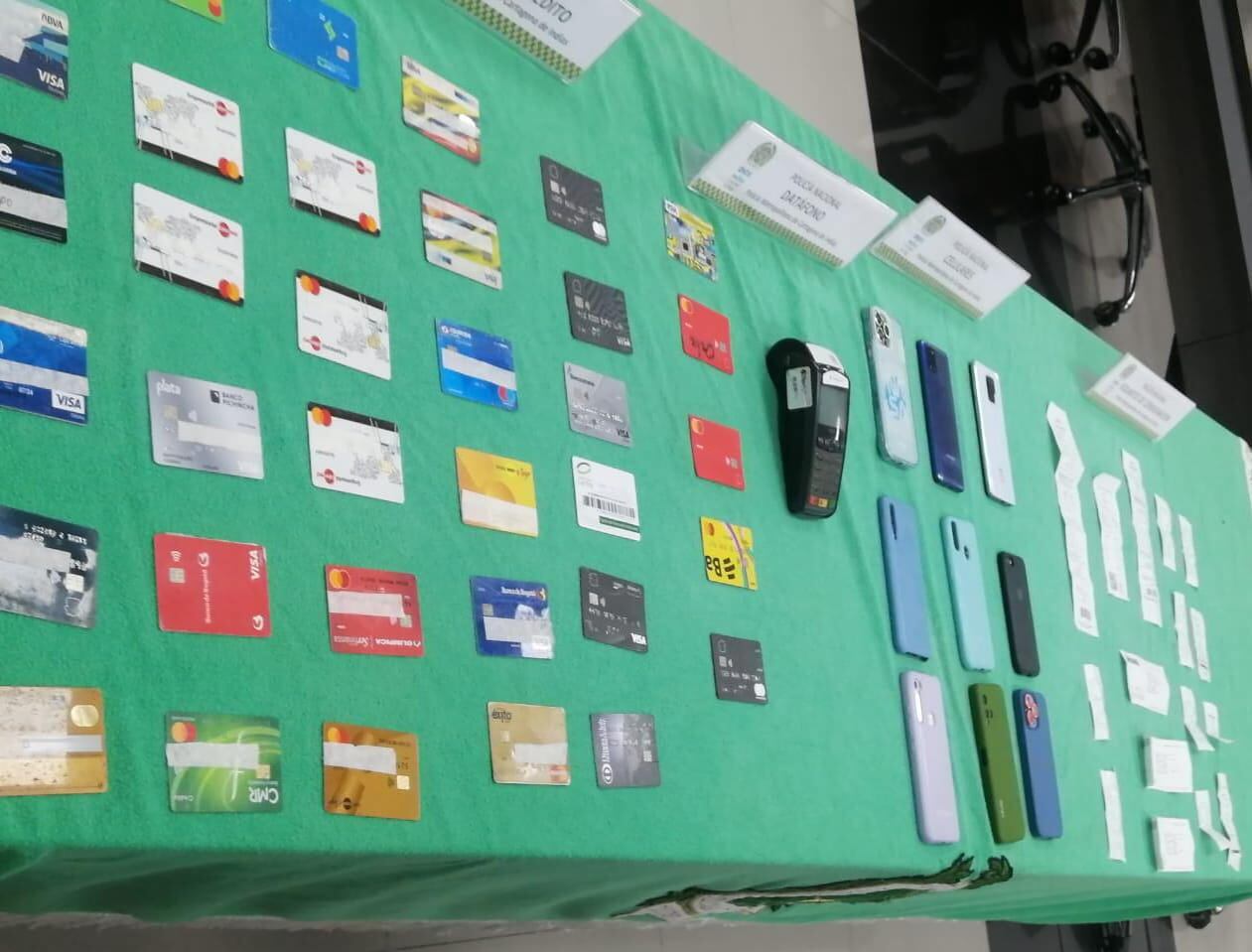 Tarjetas, celulares y otros elementos incautados en la captura.