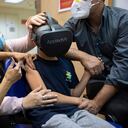 El niño israelí Rafael Peled, de 8 años, mira a través de unas gafas de realidad virtual mientras recibe una vacuna Pfizer-BioNTech COVID-19 del personal médico en el Hospital Sheba Tel Hashomer en Ramat Gan, Israel, el lunes 22 de noviembre de 2021. Israel tiene aprobó la vacuna contra el coronavirus para niños de 5 a 11 años. Foto AP / Oded Balilty