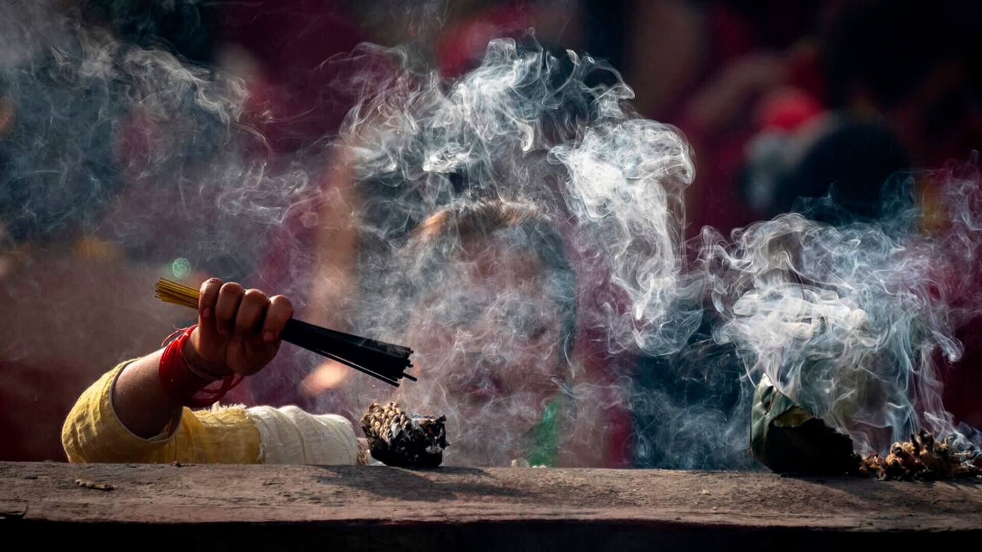 Una mujer nepalí enciende varillas de incienso y ofrece oraciones en el templo Pashupatinath