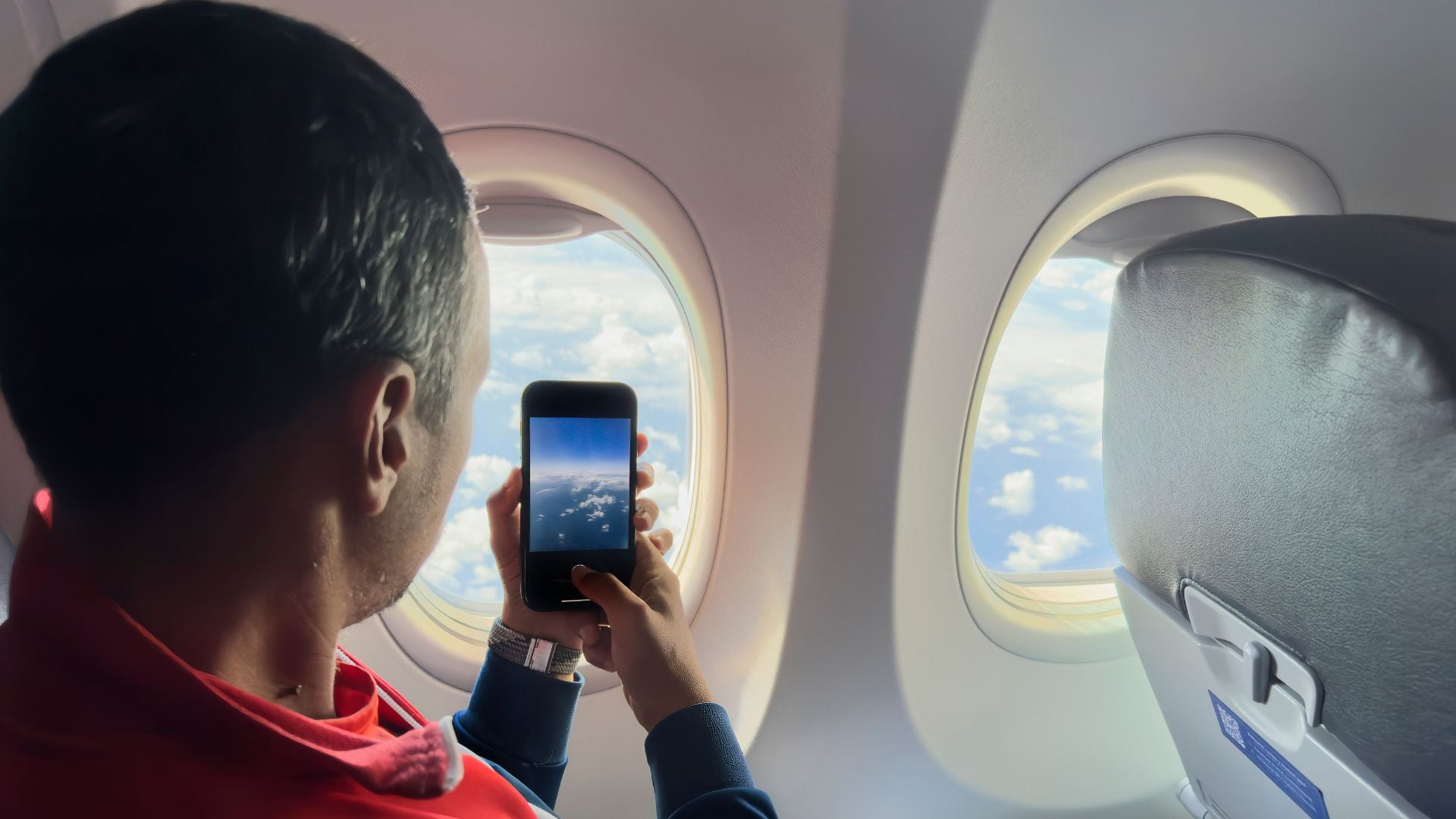 Imagen de referencia de persona tomando fotos desde el avión.