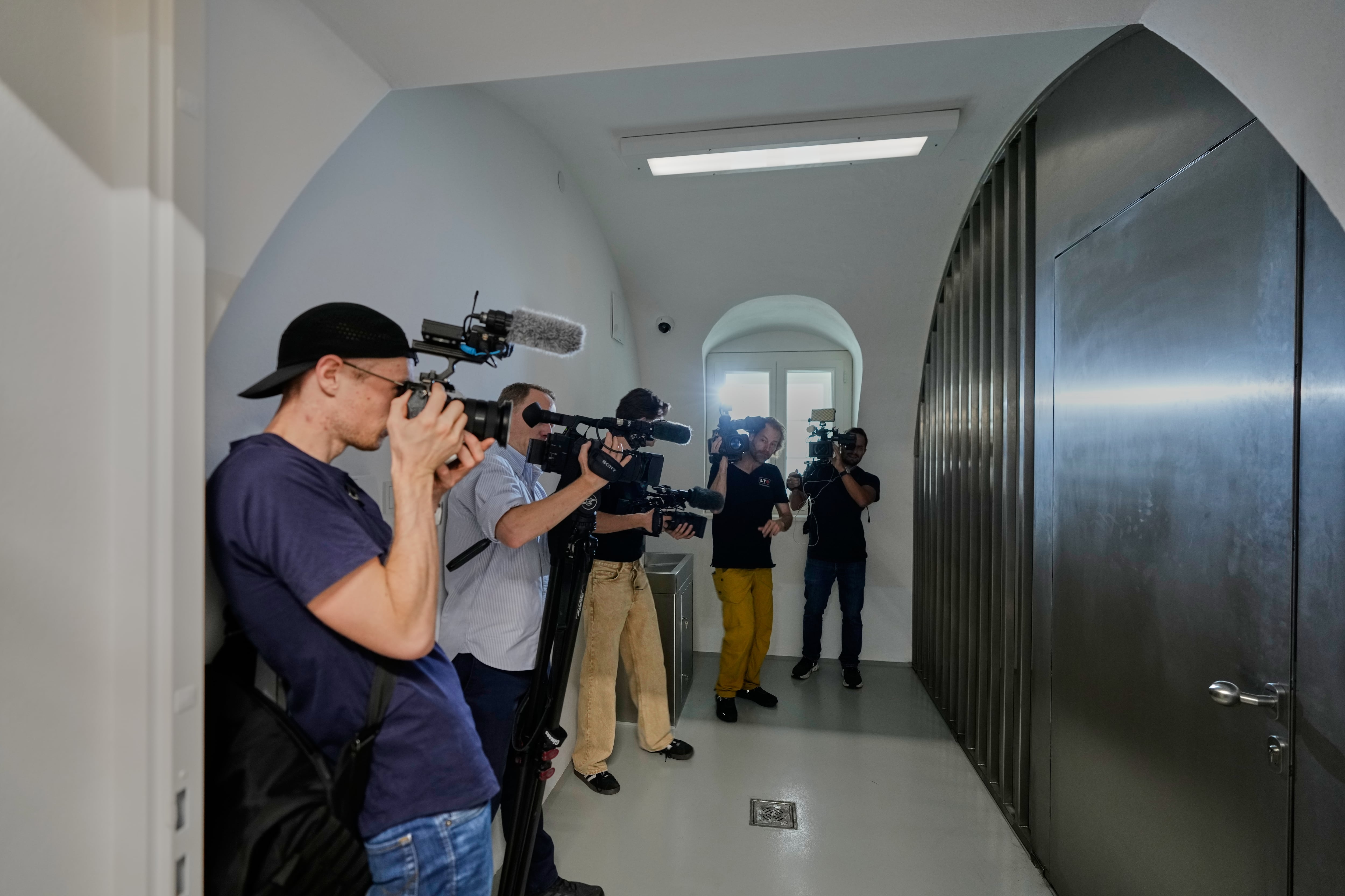 Representantes de los medios de comunicación fotografían las celdas de una nueva comisaría de policía ubicada en la casa natal de Adolf Hitler en Braunau am Inn, Austria, el miércoles 22 de julio de 2026. (Foto AP/Matthias Schrader)