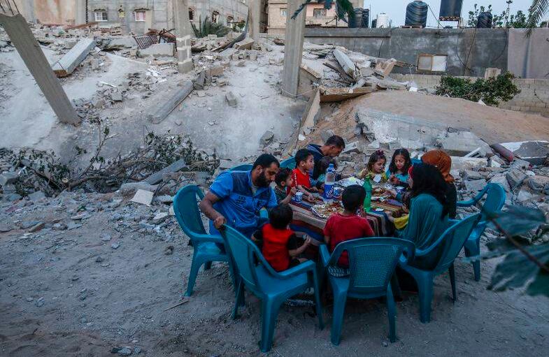 8 de mayo - Una familia palestina rompe el ayuno de Ramadán junto a su casa que fue destruida en un reciente enfrentamiento entre Hamas e Israel, en Rafah, el sur de la Franja de Gaza. FOTO: SAID KHATIB / AFP