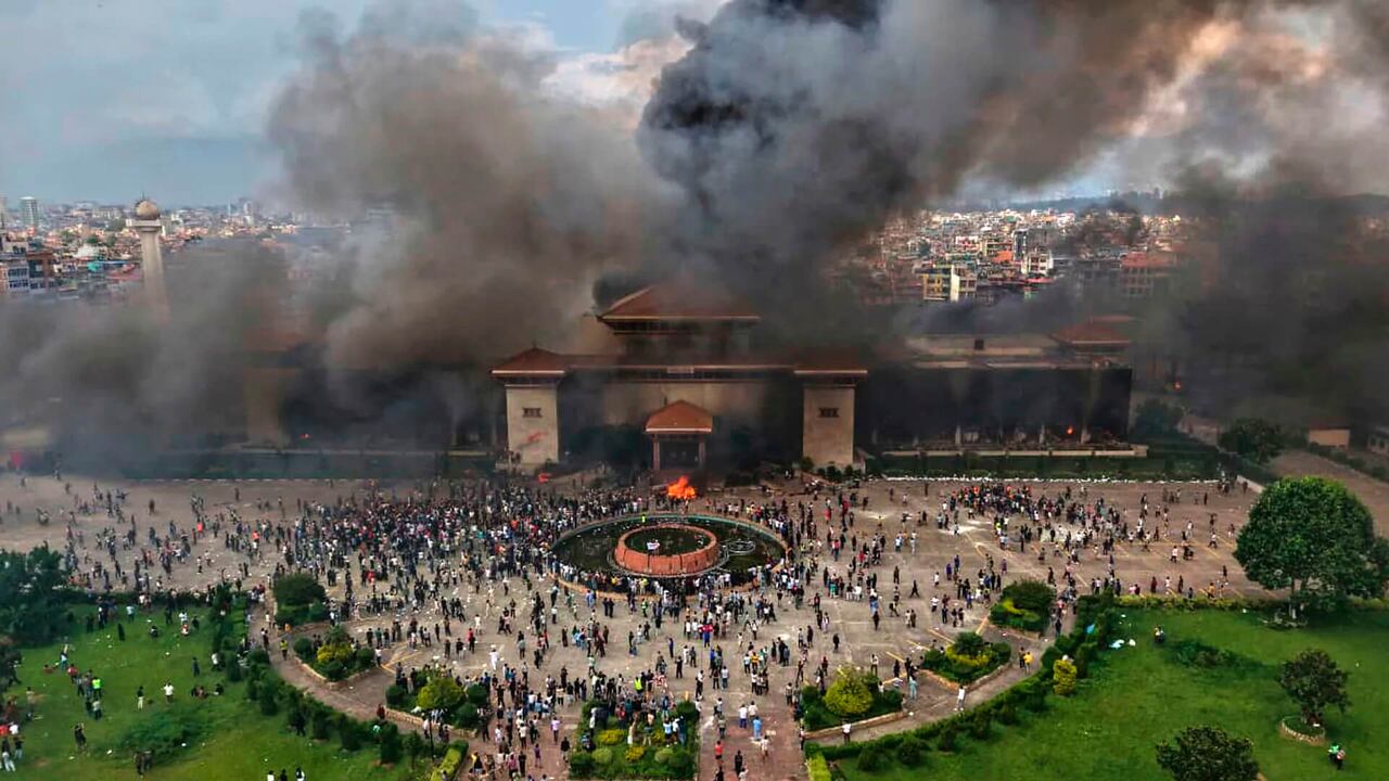 Manifestantes en el edificio del parlamento de Nepal tras incendiarlo en protesta contra la prohibición de redes sociales y la corrupción. Katmandú, martes 9 de septiembre de 2025.