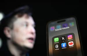 ANKARA, TURKIYE - JULY 30: In this photo illustration, the logos of various social media apps including 'X' (formerly known as Twitter) are displayed on a phone screen in front of a screen displaying the picture of Elon Musk in Ankara, Turkiye on July 30, 2023. (Photo by Aytug Can Sencar/Anadolu Agency via Getty Images)