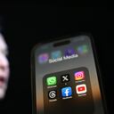 ANKARA, TURKIYE - JULY 30: In this photo illustration, the logos of various social media apps including 'X' (formerly known as Twitter) are displayed on a phone screen in front of a screen displaying the picture of Elon Musk in Ankara, Turkiye on July 30, 2023. (Photo by Aytug Can Sencar/Anadolu Agency via Getty Images)