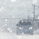Motorists navigate a city street in white out conditions.