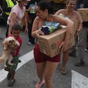 Personas afectadas por los terremotos transportan ayuda humanitaria estadounidense tras recibirla en La Guaira, Venezuela.