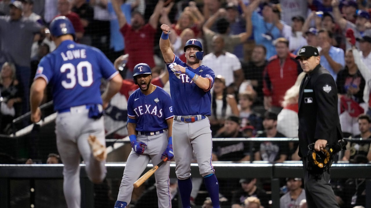 Josh Jung y Nathaniel Lowe (30) celebran después de anotar en un sencillo de Jonah Heim durante la novena entrada en el Juego 5 de la Serie Mundial de béisbol contra los Diamondbacks de Arizona.