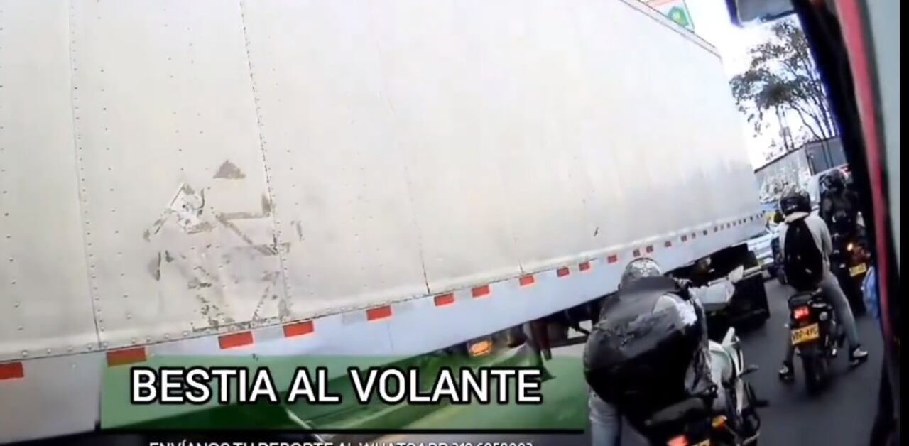 Momento en que el motociclista intenta pasar debajo de un camión.