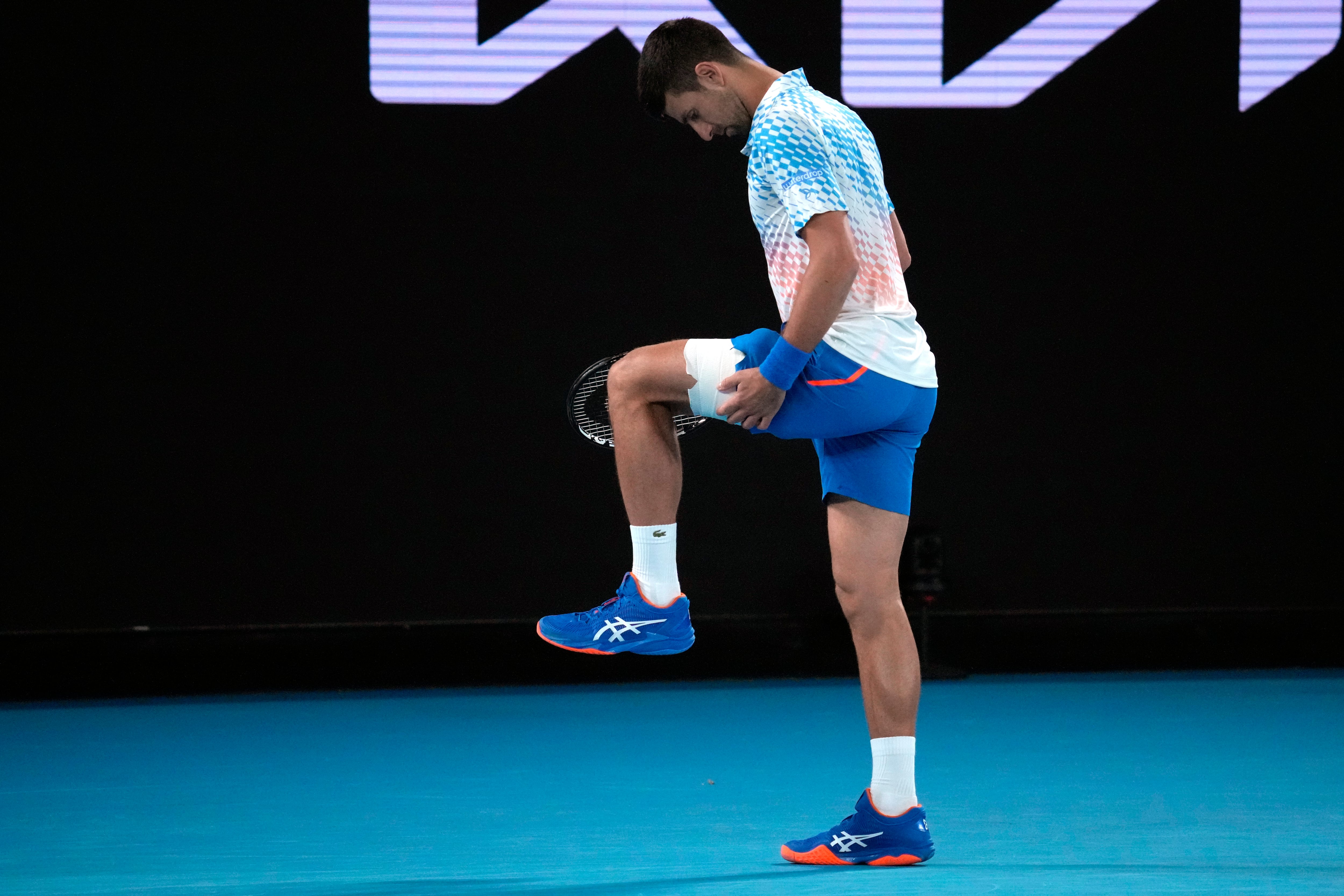 Novak Djokovic of Serbia stretches his leg during his second round match against Enzo Couacaud of France at the Australian Open tennis championship in Melbourne, Australia, Thursday, Jan. 19, 2023. (AP Photo/Dita Alangkara)