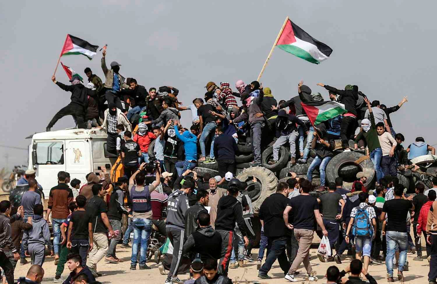 Manifestantes palestinos sostienen su bandera nacional en un camión en la frontera entre Israel y Gaza, al este de la ciudad de Gaza en el centro de la Franja de Gaza, durante el quinto viernes consecutivo de manifestaciones masivas y enfrentamientos en la frontera con Israel el 27 de abril de 2018. / AFP PHOTO / MAHMUD HAMS