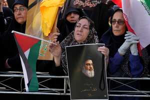 An Iranian demonstrator holds a poster of slain Hezbollah leader Hassan Nasrallah with a quotation of him: "We will definitely win," and a Palestinian flag at a rally commemorating Nasrallah, in Tehran, Iran, Wednesday, Oct. 2, 2024. (AP Photo/Vahid Salemi)