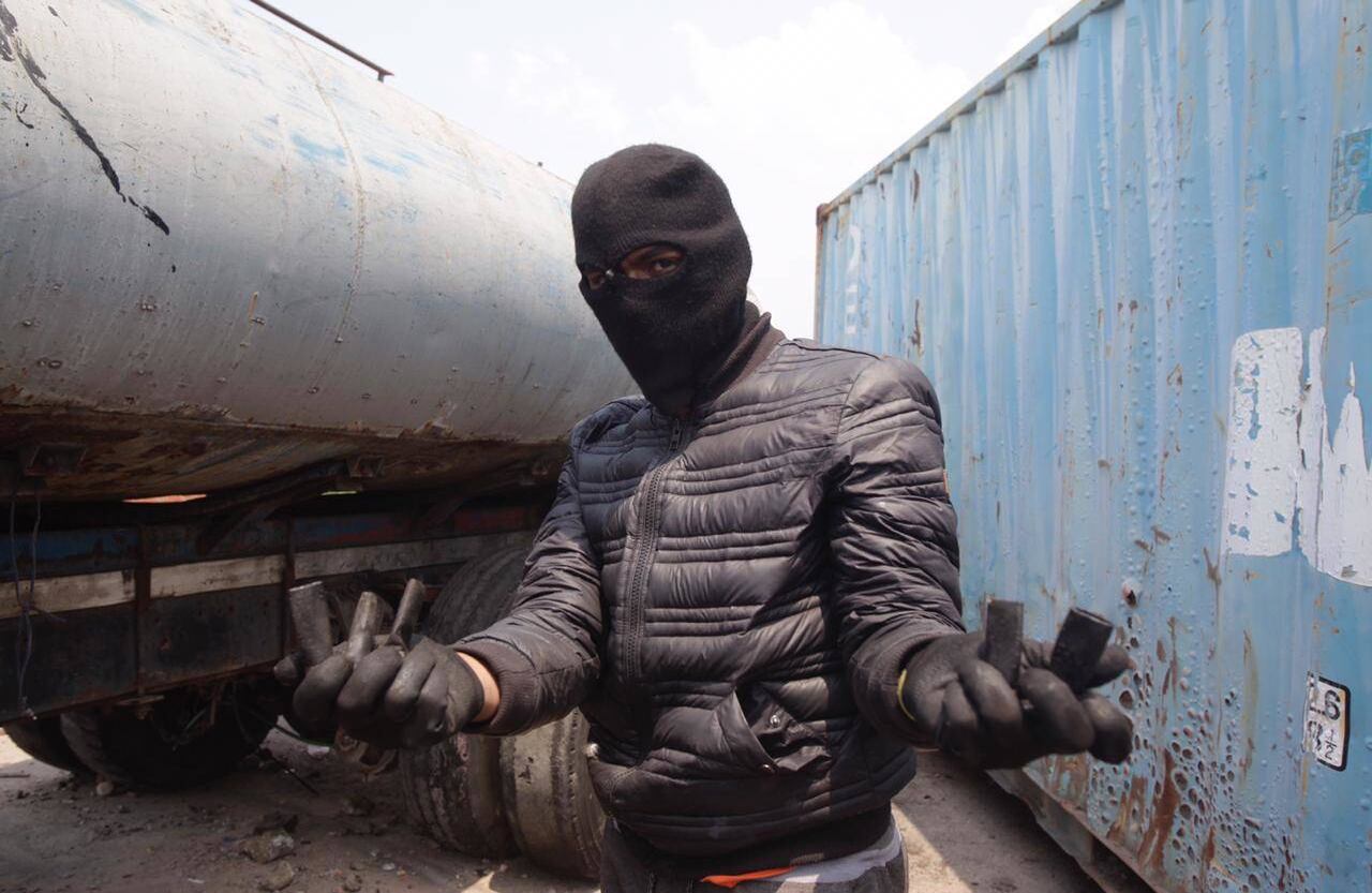 Un encapuchado recoge lo que quedó de las municiones en la zona. Foto: Diana Rey Melo SEMANA