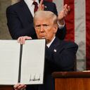 President Donald Trump displays a signed executive order as he addresses a joint session of Congress at the Capitol in Washington, Tuesday, March 4, 2025. (Win McNamee/Pool Photo via AP)