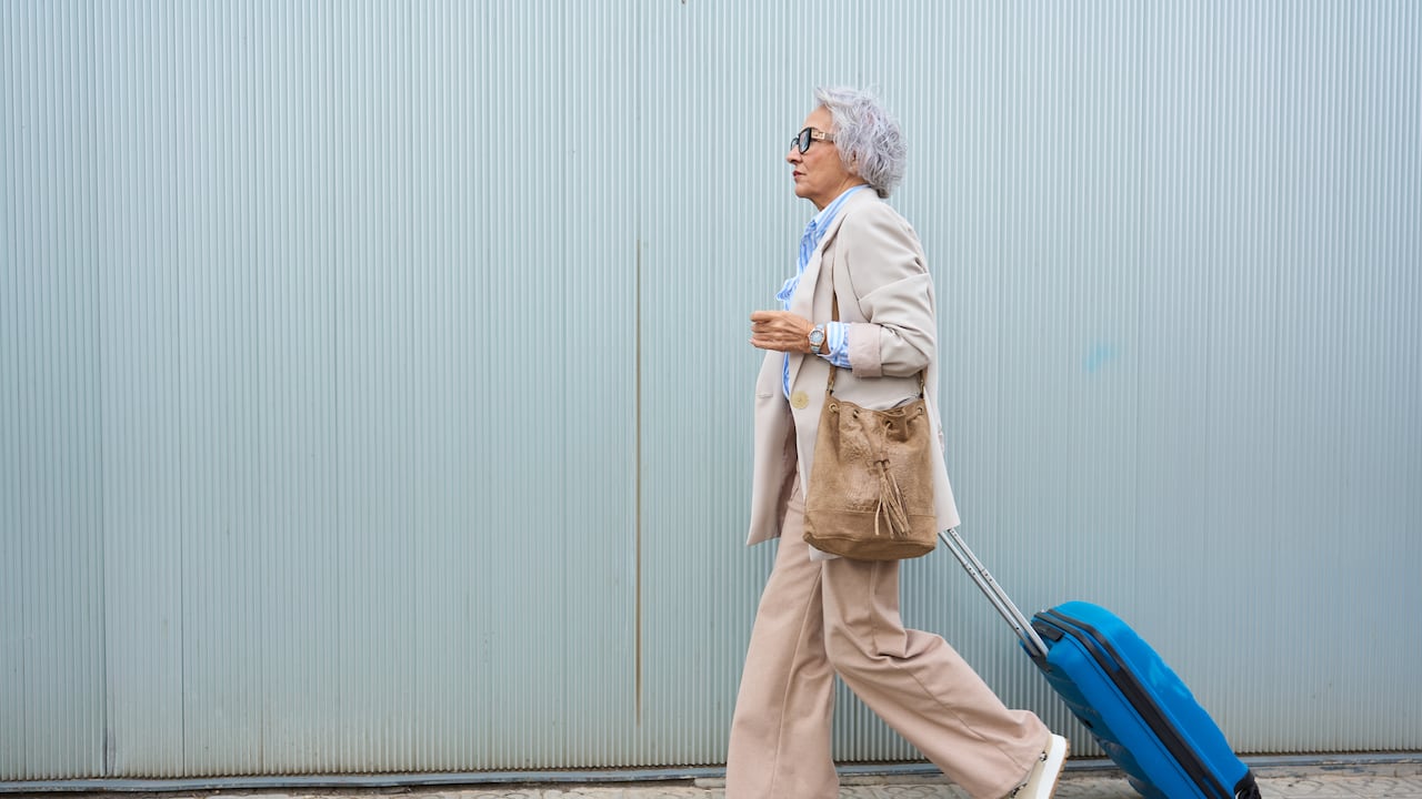Mujer mayor con maleta de viaje