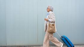 Mujer mayor con maleta de viaje
