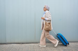 Mujer mayor con maleta de viaje