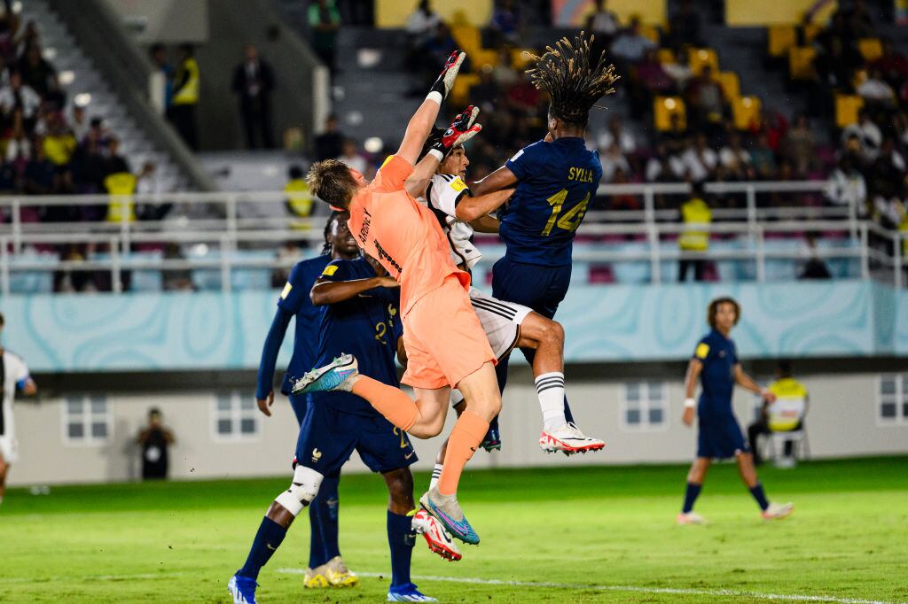 SURAKARTA, INDONESIA - DECEMBER 2: Paris Brunner of Germany (C) is challenged by Fode Sylla of France (R) during FIFA U-17 World Cup Final match between Germany and France at Manahan Stadium on December 2, 2023 in Surakarta, Indonesia. (Photo by Marcio Machado/Eurasia Sport Images/Getty Images)
