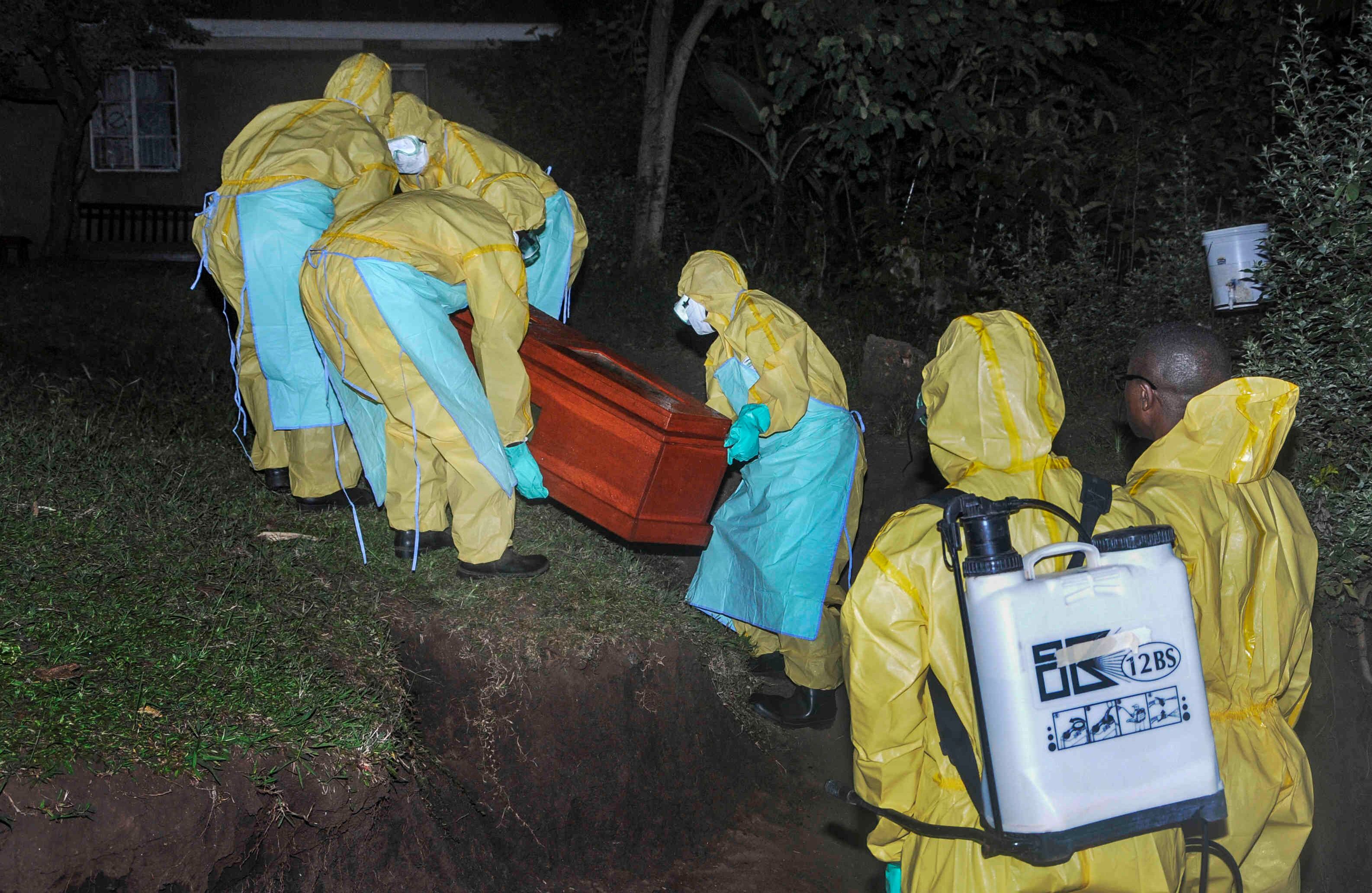  Los trabajadores entierran a Agnes Mbambu, quien murió de ébola, la abuela de 50 años del niño que se convirtió en la primera víctima transfronteriza del ébola, en la aldea de Karambi, cerca de la frontera con el Congo, en el oeste de Uganda. Jueves 13 de junio de 2019 .