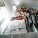 Close-up shot of blood bags full of donated blood of blood group A stacked in metal box in hospital