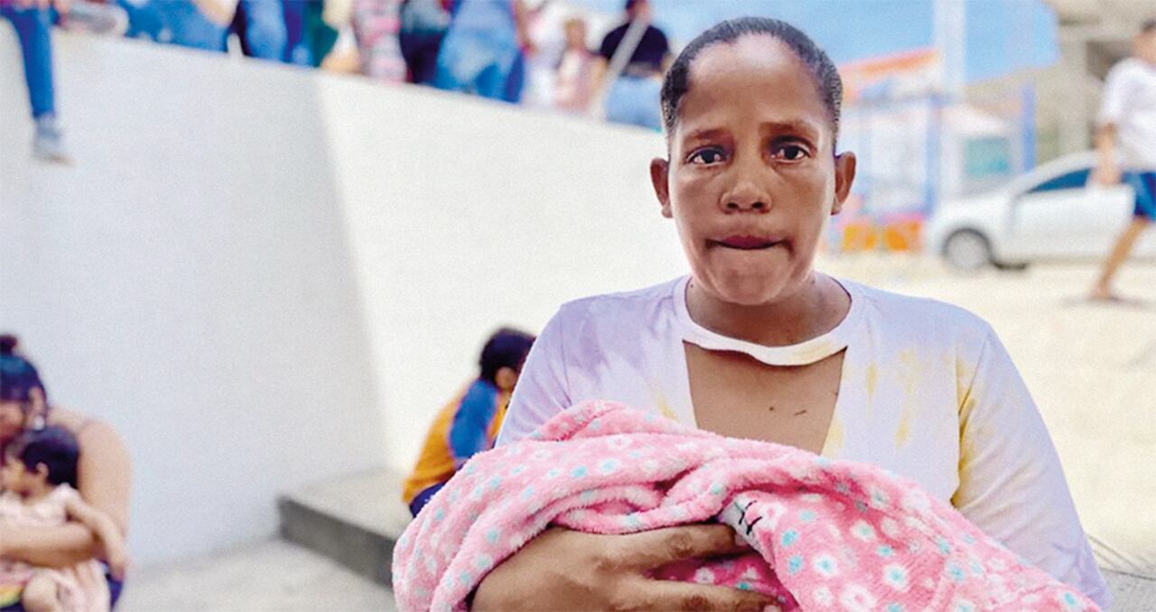 Katherine Paternera junto a su pequeño hijo recién nacido, a la espera de recibir el subsidio.