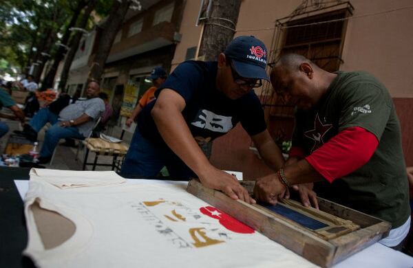 Dos hombres estampan camisetas con publicidad política apoyando al presidente de Venezuela y candidato a la reelección, Hugo Chávez.