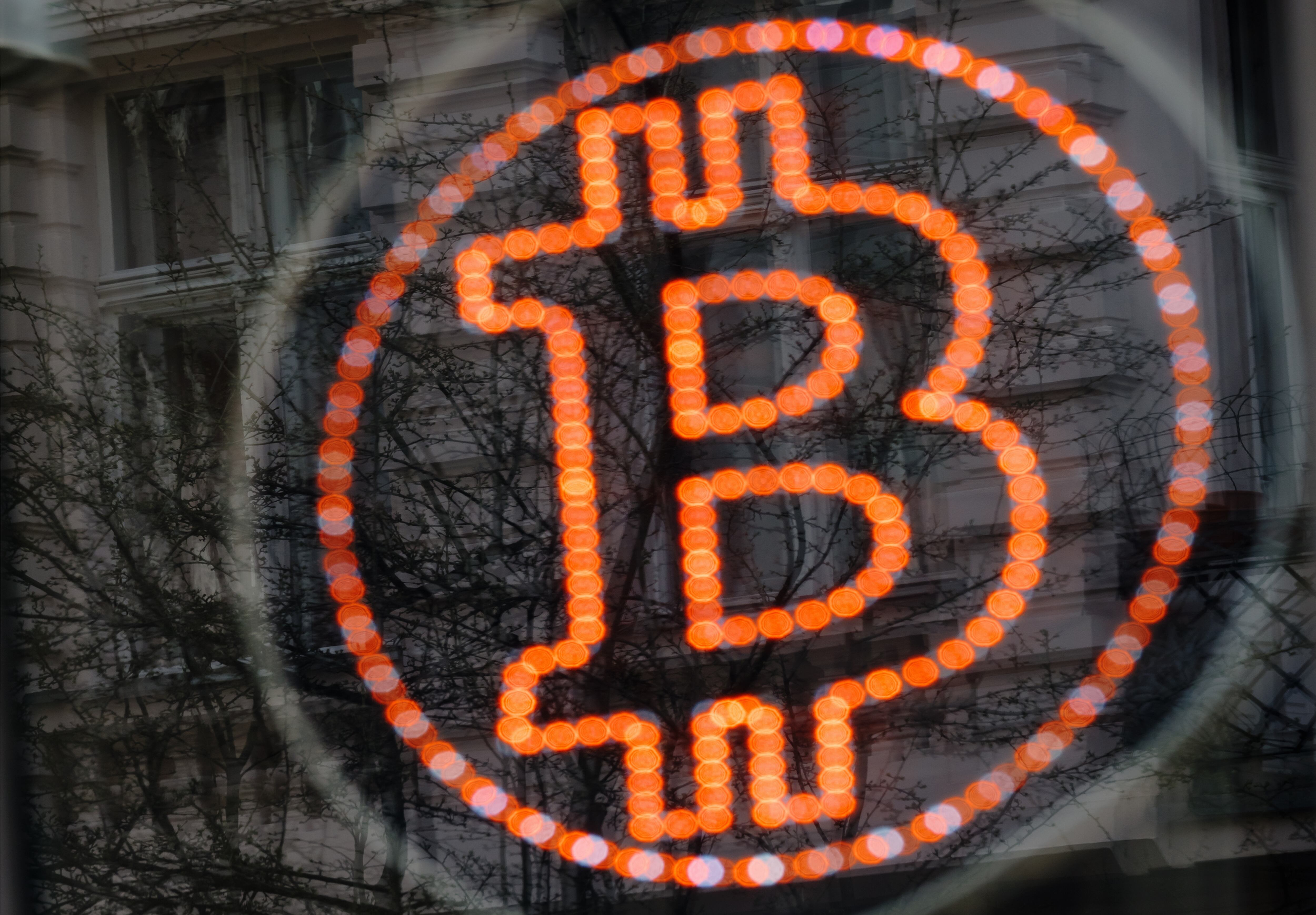A bitcoin LED sign diplayed in a shop window offers service. Getty Images.