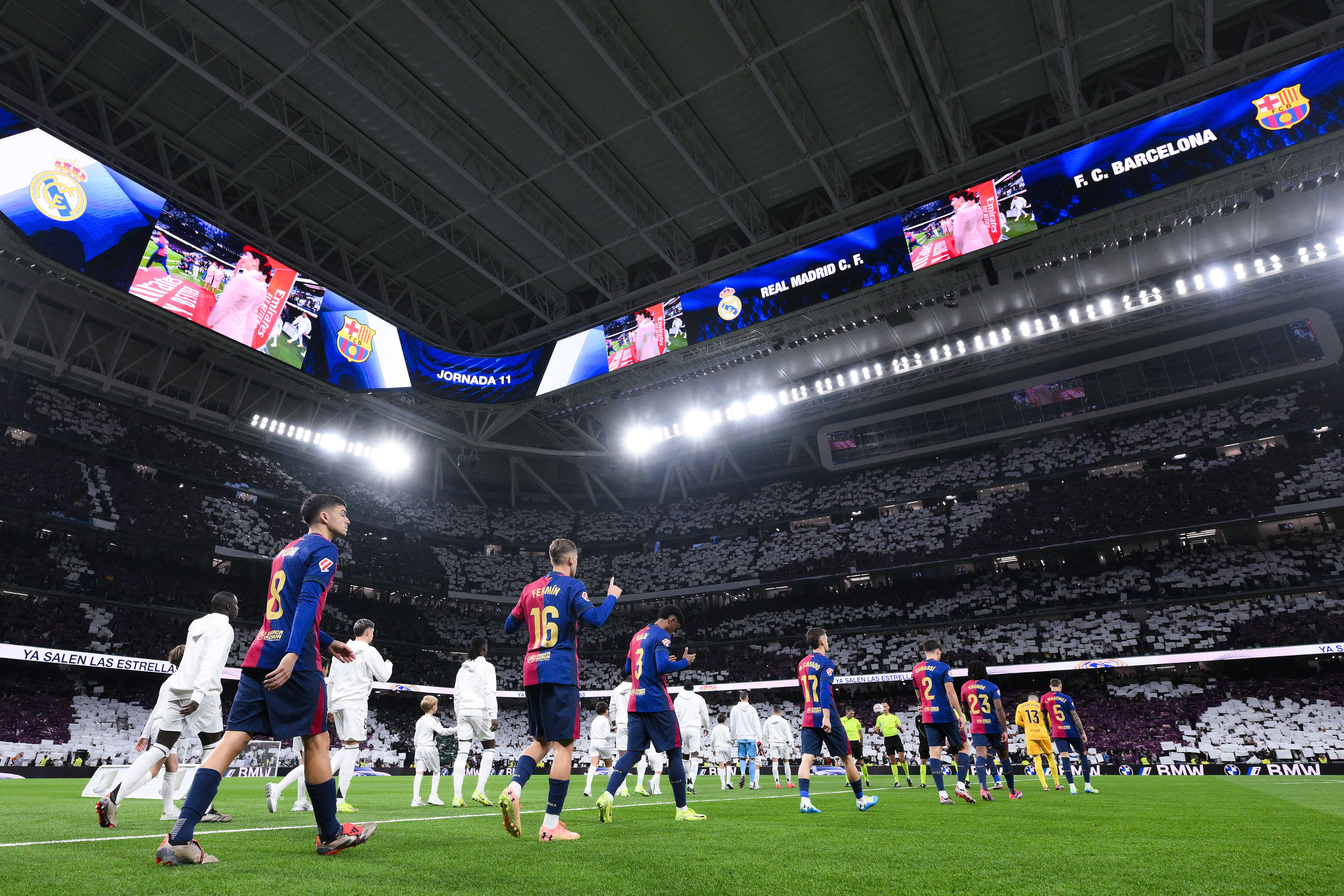 Jugadores del Barcelona y del Real Madrid CF entran en el campo antes del partido de LaLiga entre el Real Madrid CF y el FC Barcelona en el Estadio Santiago Bernabeu el 26 de octubre de 2024 en Madrid, España.