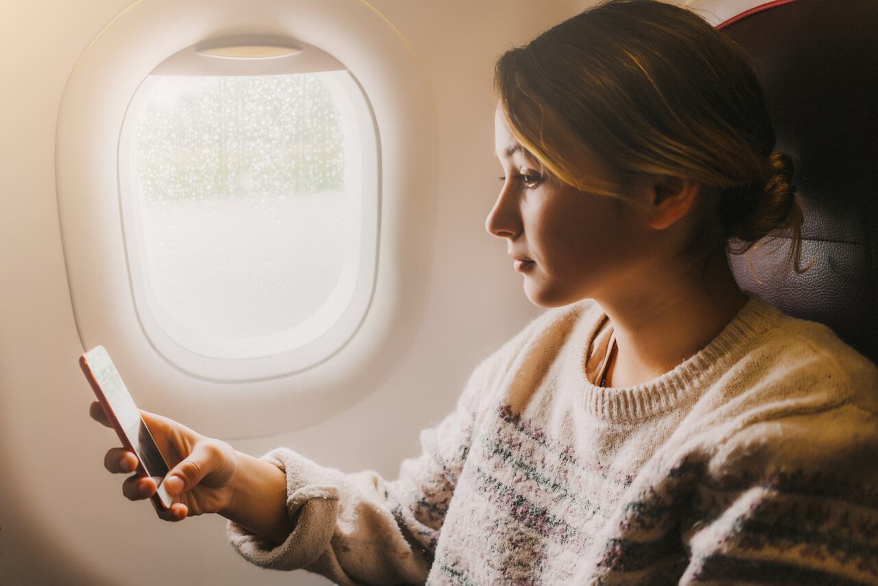 Young Caucasian woman sitting in the train and uses her smartphone