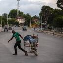 Un hombre tira de un carrito de compras cargado por una calle, vacía debido a una huelga general en Puerto Príncipe, Haití. Foto AP / Joseph Odelyn.