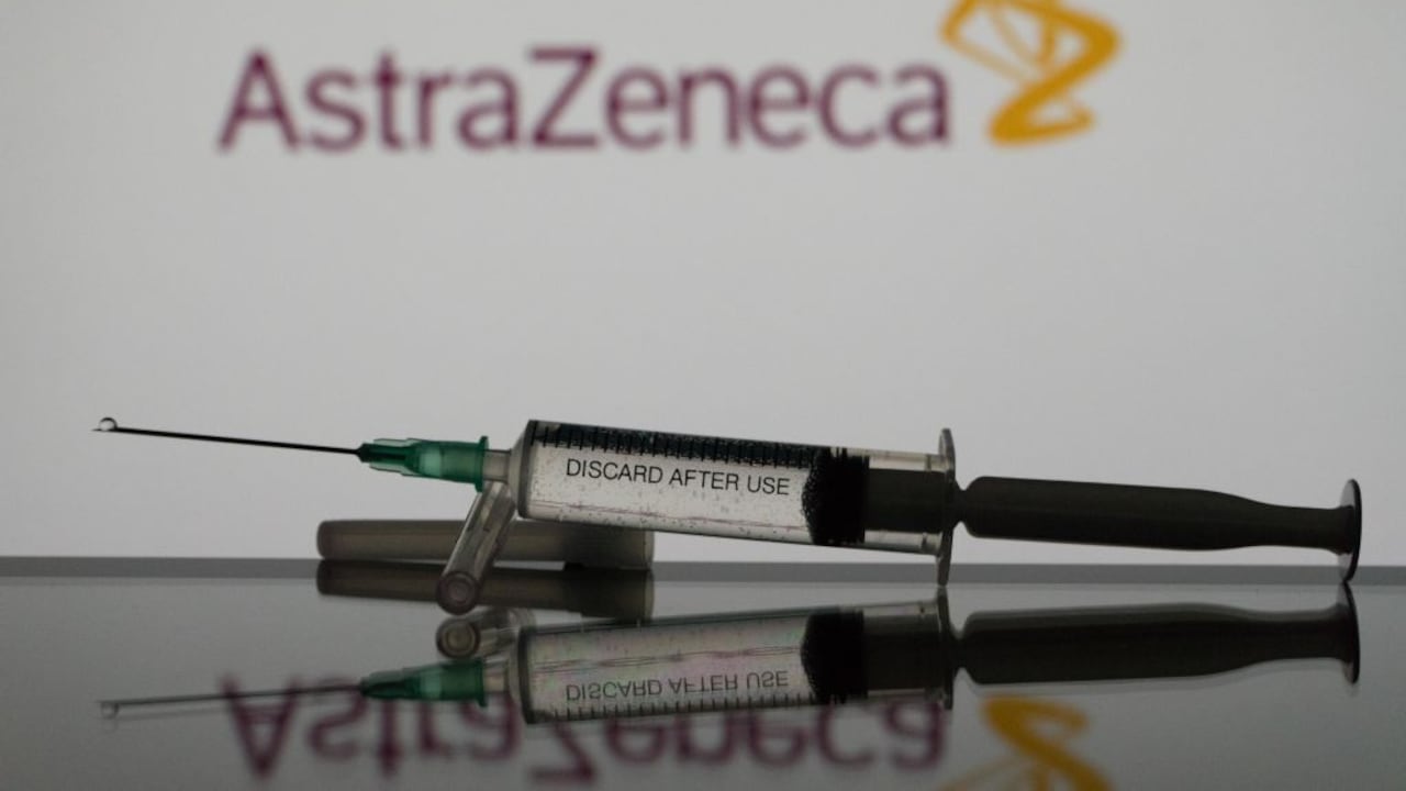 En esta ilustración fotográfica se ve una vacuna contra el covid-19 con el logo de AstraZeneca al fondo. (Ilustración fotográfica de Nikos Pekiaridis/NurPhoto vía Getty Images)