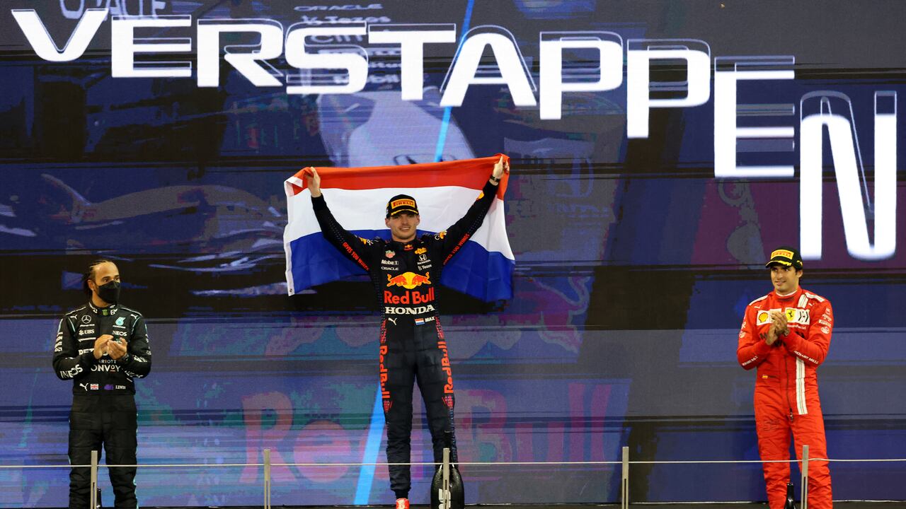 (fromL) Second-placed Mercedes' British driver Lewis Hamilton, 2021 FIA Formula One World Champion Red Bull's Dutch driver Max Verstappen and third-placed Ferrari's Spanish driver Carlos Sainz Jr celebrate on the podium of the Yas Marina Circuit after winning the Abu Dhabi Formula One Grand Prix on December 12, 2021. - Max Verstappen became the first Dutchman ever to win the Formula One world championship title when he won a dramatic season-ending Abu Dhabi Grand Prix. (Photo by Giuseppe CACACE / AFP)