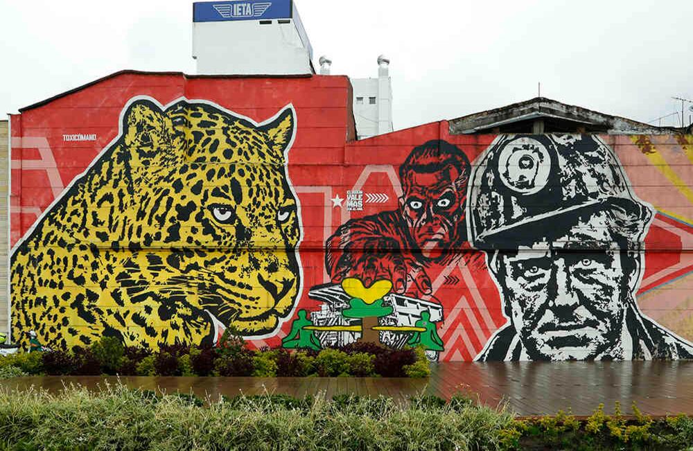 Toxicómano. Este grafiti es una crítica contra la minería y la manera en  que se han venido manejando los recursos naturales. “Es un enfrentamiento  entre los grandes monopolios y la gente local, que en este caso están  representados por el jaguar que vigila lo que está sucediendo.” Toxicómano