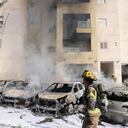 Equipos de bomberos israelíes apagan el incendio en un estacionamiento afuera de un edificio residencial después de un ataque con cohetes desde la Franja de Gaza en la ciudad sureña israelí de Ashkelon el 7 de octubre de 2023. El ministro de Defensa del país afirmó el 7 de octubre que militantes palestinos han iniciado una "guerra" contra Israel después de una ráfaga de cohetes y la infiltración de combatientes desde el enclave palestino, lo que representa una escalada importante en el conflicto israelí-palestino. (Foto de AHMAD GHARABLI / AFP).