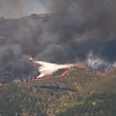 Un avión arroja agua sobre un incendio activo cerca de La Adrada, en la provincia de Ávila, España.