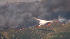Un avión arroja agua sobre un incendio activo cerca de La Adrada, en la provincia de Ávila, España.