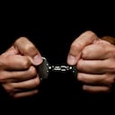 Handcuffes on man hand's on black background