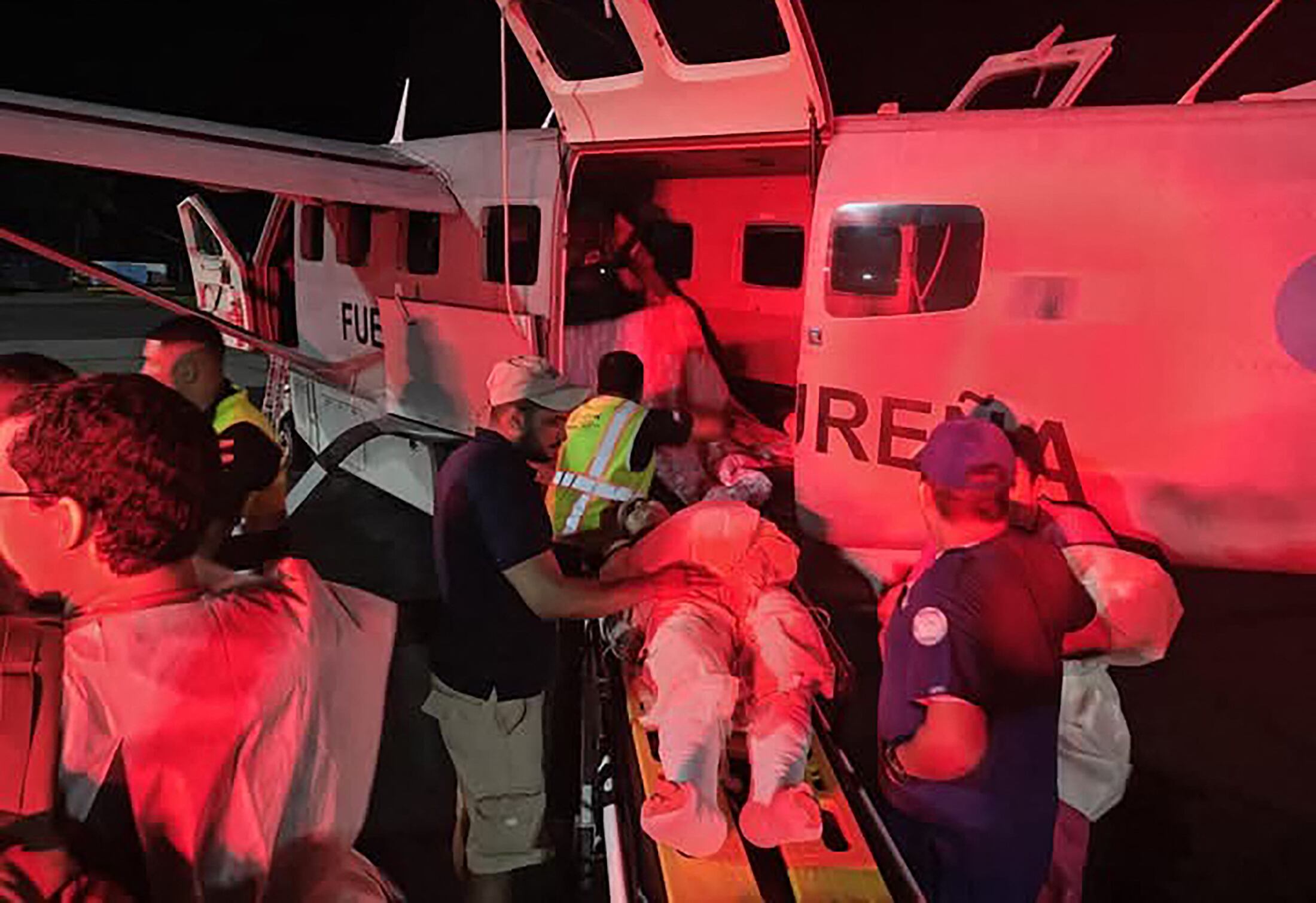 Imagen difundida por la Fuerza Aérea Hondureña muestra a los equipos de rescate transportando a un herido a un avión de la Fuerza Aérea tras un accidente aéreo en Roatán, Honduras, el 17 de marzo de 2025. Al menos seis personas murieron cuando una avioneta con 17 pasajeros a bordo se salió de la pista al despegar de la isla caribeña hondureña de Roatán y se estrelló en el mar, informaron los bomberos.