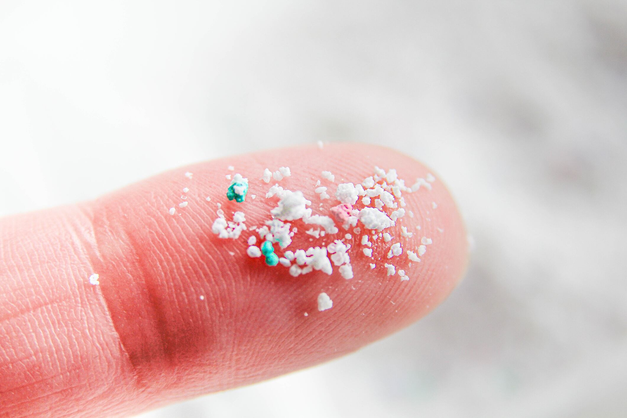 Microplastic, finger close up