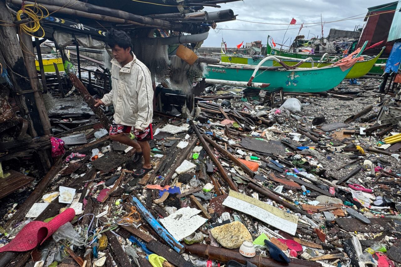 Un hombre camina sobre los escombros arrastrados a la costa por el tifón Fung-wong en un pueblo costero el lunes 10 de noviembre de 2025 en Navotas, Filipinas. (Foto AP/Aaron Favila)